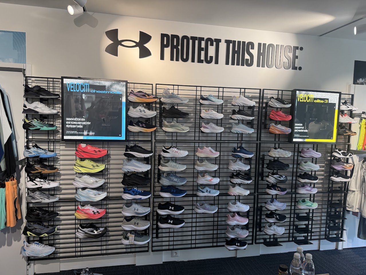 Стена с изложени спортни обувки Under Armour